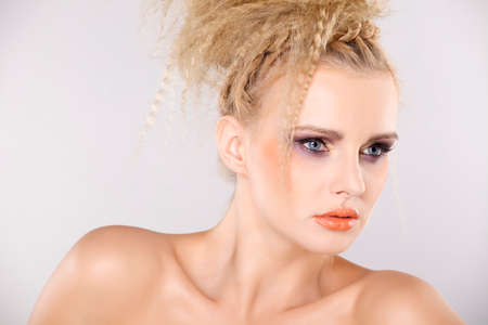 Young pretty woman with beautiful blond hairs and multicolor makeup isolated on white backgroundの写真素材