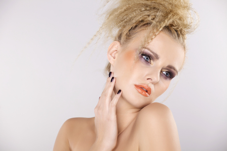 Young pretty woman with beautiful blond hairs and multicolor makeup isolated on white backgroundの写真素材