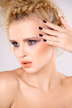 Young pretty woman with beautiful blond hairs and multicolor makeup isolated on white backgroundの写真素材