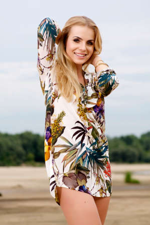 young adult sensuality attractive pretty blonde woman in flower's dress on the beachの写真素材