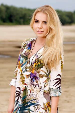 young adult sensuality attractive pretty blonde woman in flower's dress on the beachの写真素材