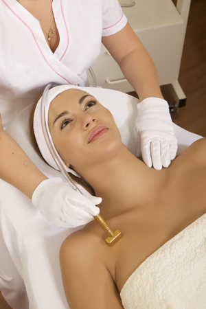 Young brunette woman receiving laser therapy. Spa studio shotの写真素材