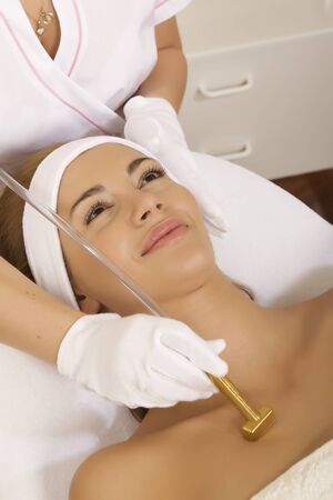 Young brunette woman receiving laser therapy. Spa studio shotの写真素材