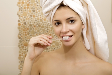 Portrait pretty female woman brushing her teeth in bathroomの写真素材