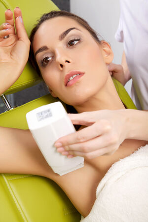 Young brunette woman receiving laser therapy. Spa studio shotの写真素材