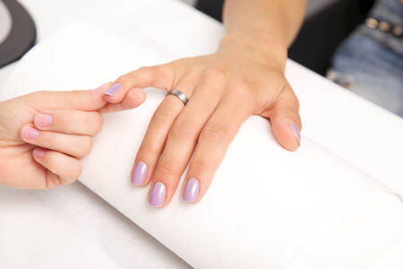 Manicure - Beautiful manicured woman's nails with violetnail polish on soft white towel.の写真素材