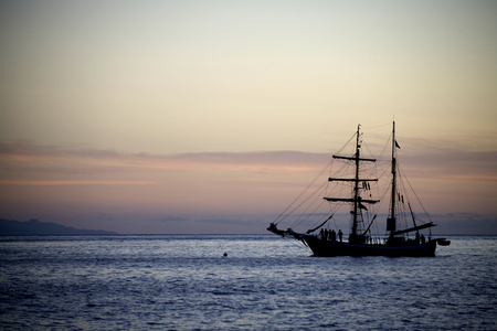 Sailing yaht in open sea on beautiful sunset sky backgroundの写真素材