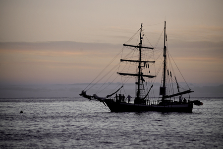 Sailing yaht in open sea on beautiful sunset sky background