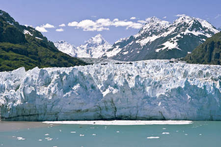 Glacier sliding toward the ocean colors the water as it calves.の写真素材