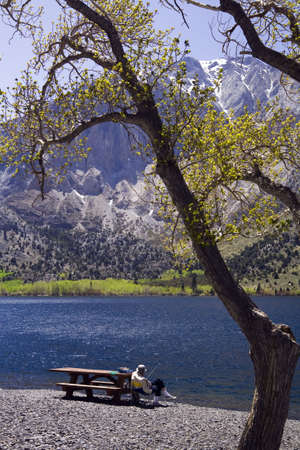 Man Fishing from picnic table at Convict Lake, CA.の写真素材