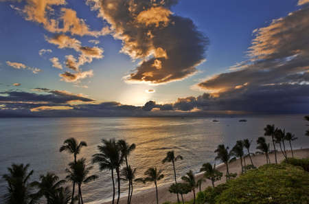 Sunset casts a golden glow over  Kaanapali Beach on Maui.の写真素材
