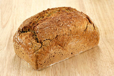 a loaf of bread on a wooden breadboardの写真素材