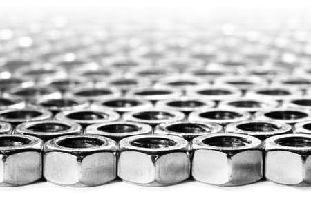 screw nuts laying on a white surface in a patterned styleの写真素材