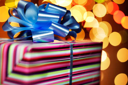 A present tied with a blue bow on a background of glimmering lights