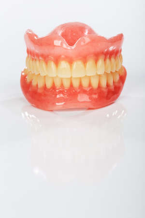 A set of dentures on a shiny white backgroundの写真素材