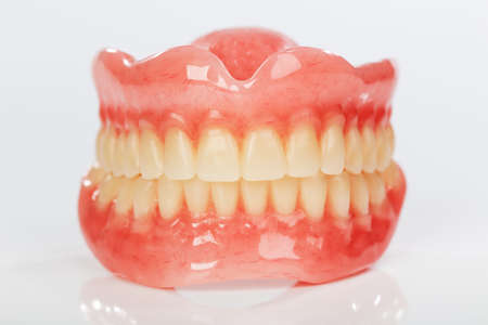 A set of dentures on a shiny white backgroundの写真素材
