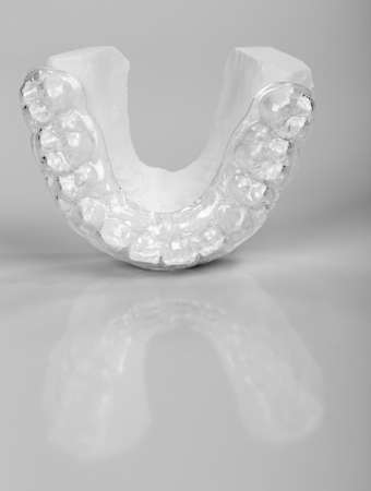 Translucent upper essix retainer on a plaster study model placed on a gray backgroundの写真素材