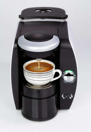 A black modern espresso coffee machine is making a coffee on a white backgroundの写真素材