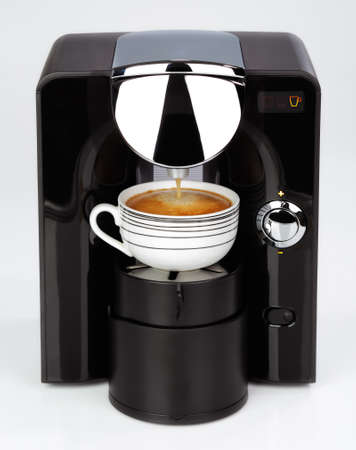 A black modern espresso coffee machine is making a coffee on a white backgroundの写真素材