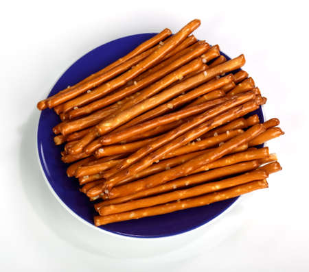 Salty bread finger snacks on a blue plate placed on a white backgroundの写真素材