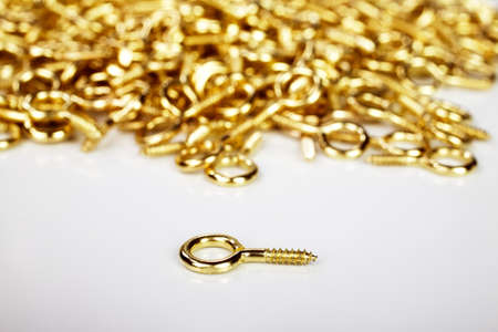 Golden hooks used by framers to stretch a rope on the back of a picture frame on a white backgroundの写真素材
