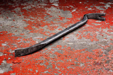 An old crowbar on a red backgroundの写真素材