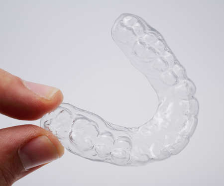Hand holding a translucent upper essix retainer