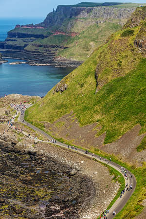 Thousands of tourists visiting Giant's Causeway in County Antrim of Northern Ireland, a World Heritage Site by UNESCO containing about 40000 interlocking basalt columns from ancient volcanic eruptionのeditorial素材