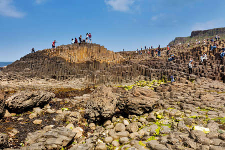Thousands of tourists visiting Giant's Causeway in County Antrim of Northern Ireland, a World Heritage Site by UNESCO containing about 40000 interlocking basalt columns from ancient volcanic eruptionのeditorial素材