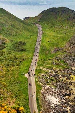 Thousands of tourists visiting Giant's Causeway in County Antrim of Northern Ireland, a World Heritage Site by UNESCO containing about 40000 interlocking basalt columns from ancient volcanic eruptionのeditorial素材