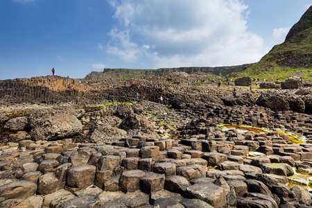 Thousands of tourists visiting Giant's Causeway in County Antrim of Northern Ireland, a World Heritage Site by UNESCO containing about 40000 interlocking basalt columns from ancient volcanic eruptionのeditorial素材