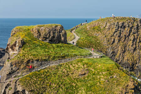 Carrick-a-Rede Rope Bridge in County Antrim of Northern Ireland, hanging 30m above rocks and spanning 20m, linking mainland with the tiny island of Carrickaredeのeditorial素材