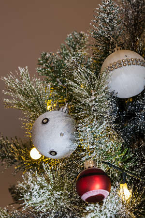 Christmas lights, baubles, stars and other seasonal decorations on a snow frosted xmas treeの写真素材