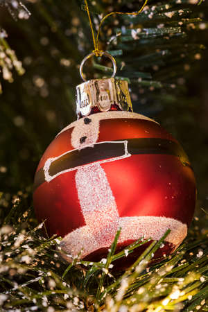Christmas lights, baubles, stars and other seasonal decorations on a snow frosted xmas treeの写真素材