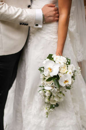 bride in a white tuxedo hugs the waist brideの写真素材