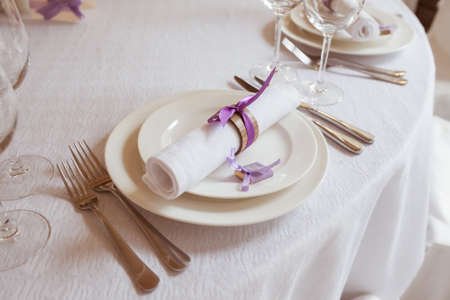 served table in a restaurant, focus on a napkin on the plateの写真素材