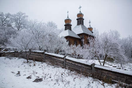 an old church of wood among the trees in the snowの写真素材