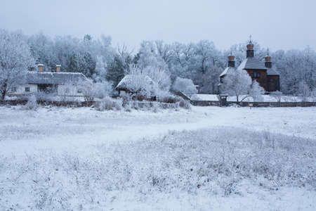 an old church of wood among the trees in the snowの写真素材