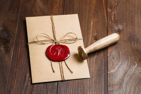 Craft envelope with wax seal of a dark wooden backgroundの写真素材