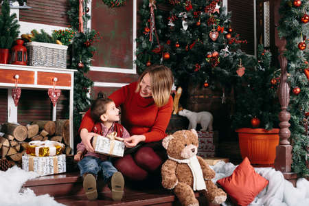 Beautiful woman gives a gift to his son. Boy and woman smile at each other.の写真素材