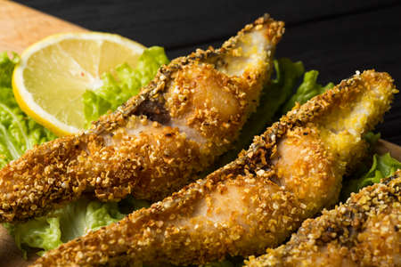 fried fish on a wooden board with lettuce close up