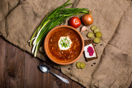 Ukrainian borsch with sour cream and garlic buns on the table.の写真素材