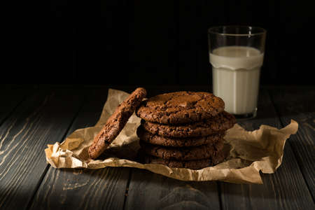 Stack of Chocolate chip cookies on paper on wooden backgroundの写真素材