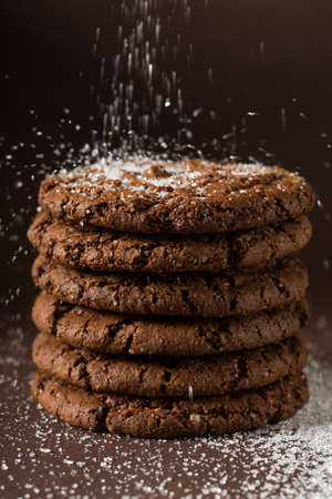 Stack of Chocolate chip cookies on brown background. Stacked chocolate chip cookies shot with selective focus.の写真素材