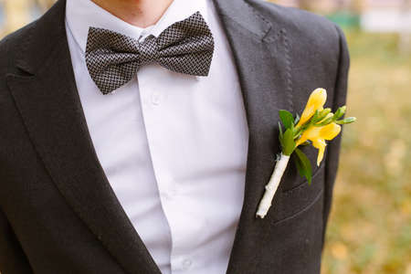 freesia pinned to the lapel of the groomの写真素材