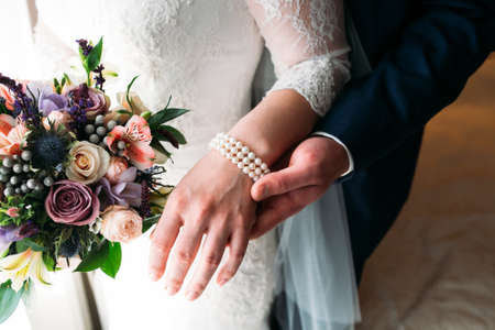 Detail of bride's roses bouquet and hands holdingの写真素材