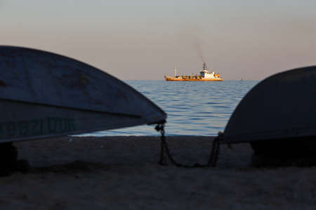 MARIUPOL, UKRAINE - SEPTEMBER 5, 2016: Sea sunset and silhouette of navy shipのeditorial素材