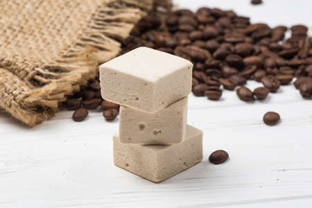 marshmallow, coffee grains and sackcloth on a wooden backgroundの写真素材