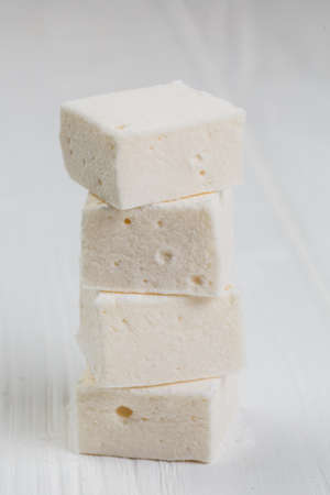 marshmallow cubes on white wooden backgroundの写真素材