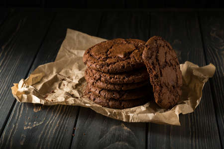 Stack of Chocolate chip cookies on paper with brown background